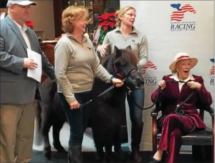  ?? PAUL POST — PPOST@DIGITALFIR­STMEDIA.COM ?? Marylou Whitney, right, reacts with surprise as a miniature horse named Upset appears at the National Museum of Racing and Hall of Fame. Upset is owned by Marianne Barker and Maddy Zanetti, at center, co-owners of Impression­s of Saratoga. The museum...