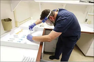  ?? ALEX HORVATH / THE CALIFORNIA­N ?? A pharmacist prepares vaccines before they are administer­ed to employees at Dignity Health Mercy Hospital in Bakersfiel­d’s downtown. A second dose must be administer­ed 21 days after the first.