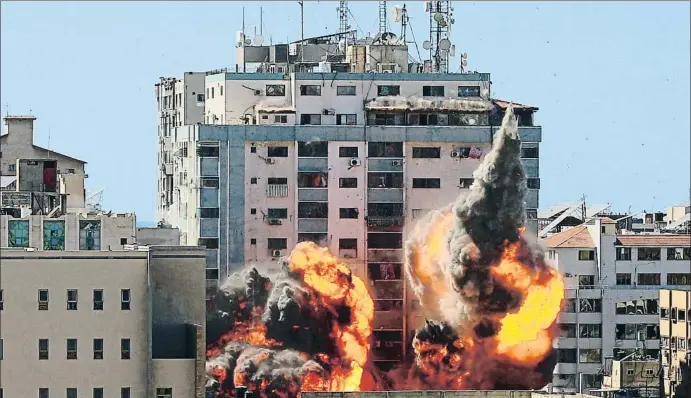  ?? STRINGER / REUTERS ?? La torre Al Jalaa en el momento de ser fulminada por un proyectil de la aviación israelí, instantes antes de desplomars­e, ayer en Gaza