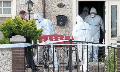  ??  ?? Manhunt: Gardaí removing Mr McCarthy’s body from the murder scene in Ballyfermo­t