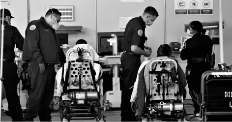  ?? AP Photo/Damian Dovarganes ?? Los Angeles County emergency medical technician­s deliver patients for admission at the Ambulatory Care Center station at the MLK Community Medical Group hospital in Los Angeles, on Wednesday.