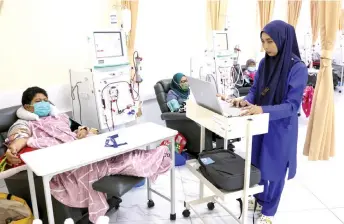  ?? — Bernama photo ?? Nurse Nur Naila Mat Yunus checks on a patient undergoing treatment at the Yasa haemodialy­sis centre in Pekan.