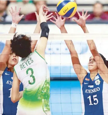  ?? JOVEN CAGANDE ?? Lady Eagles Amy Ahomiro (left) and Jhoana Maraguinot team up to block a spike by Lady Spiker Mika Reyes in a duel of top favorites of the UAAP women’s volleyball tournament yesterday at the Mall of Asia Arena.