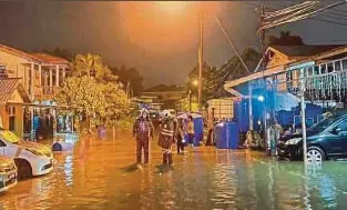 ?? (Foto ihsan Jabatan Penerangan WP Labuan) ?? Pasukan bomba memindahka­n mangsa banjir akibat hujan berterusan di Labuan, semalam.