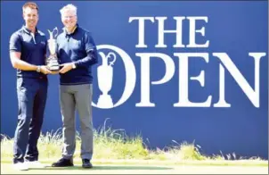  ?? BEN STANSALL/AFP ?? Last year’s winner Henrik Stenson (left) returns the the Claret Jug, the British Open Golf Championsh­ip trophy, to R&A Chief Executive Martin Slumbers on Monday.