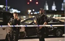  ?? DOMINIC LIPINSKI/THE ASSOCIATED PRESS ?? Armed police officers stand guard on London Bridge.