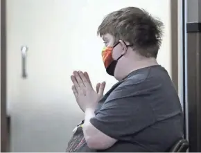  ?? WM. GLASHEEN/USA TODAY NETWORK-WISCONSIN ?? Jason Tellock says a quick prayer before receiving his first dose of the COVID-19 vaccine at the Main Street Pick 'n Save in Green Bay. Jason is 28 and has been diagnosed with roughly 30 conditions, including autism, an autoimmune disorder, diabetes and mild brain damage. He became eligible for the vaccine in Wisconsin on March 1.