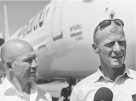  ?? GRAHAM HUGHES/THE CANADIAN PRESS ?? CEOs Alain Bellemare of Bombardier, left, and Tom Enders of Airbus are facing stronger competitio­n after the tie-up between Boeing and Embraer. Analysts believe the deal will be a slight drawback for Bombardier as its main rival Embraer gets a boost.