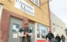  ??  ?? Robert Andersen waits in line in front of Riverside Mission before entering to grab his hot to-go supper and a loaf of bread or bag of buns. The organizati­on has changed how it feeds residents to ensure they and mission staff remain healthy and safe. Photo by Jason G. Antonio