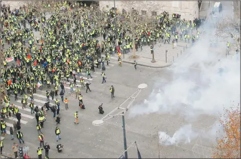  ??  ?? Riot police fire tear-gas canisters at yellow-vested protesters gathered on the famed Champs-Elysees Avenue in Paris, on Dec 8. (AP)