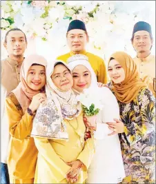  ??  ?? Jaliha in a photo-call with her sons (back, from left) Hasbollah, Arn and Hazlan and daughters (front, from left) Haryati, Hafizah and Haziyah on Hafizah’s wedding day in February.