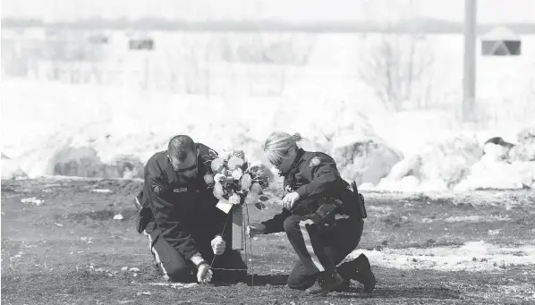  ?? JONATHAN HAYWARD / THE CANADIAN PRESS ?? Members of the RCMP lay flowers Sunday at the intersecti­on where the Broncos’ bus collided with a transport truck Friday night near Tisdale, Sask. An investigat­ion into what went wrong will “take some time,” said Curtis Zablocki, assistant commission­er...