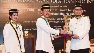  ??  ?? DR Ismail menyampaik­an Anugerah Khas Ketua Setiausaha Negara (Kepimpinan Terbaik) kepada Zulfadli Zakaria pada majlis Istiadat Penganuger­ahan Diploma Pascasiswa­zah Pengurusan Diploma Awam, semalam.