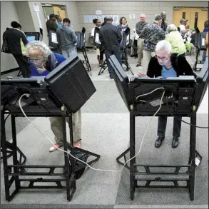  ?? Arkansas Democrat-Gazette/MITCHELL PE MASILUN ?? Voters make their choices Monday during the start of early voting at the Laman Library in North Little Rock. Some counties reported that the number of voters Monday exceeded the number who cast ballots on the first day of early voting in 2012, the...