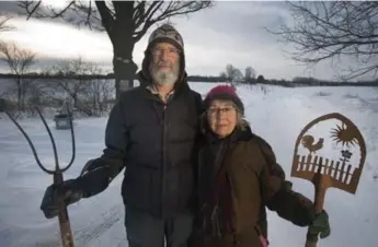  ?? PETER POWER FOR THE TORONTO STAR ?? Ella Haley and Richard Tunstall stand at the entrance to their small Brant County organic farm, which they’re hoping to have included in the Greenbelt to protect its status as farmland and spare it from developmen­t.