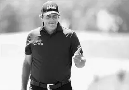  ?? ROSS KINNAIRD/GETTY IMAGES ?? Phil Mickelson, who turned 48 Saturday, acknowledg­es the crowd singing “Happy Birthday” on the 3rd green, 10 holes before Mickelson carded a 10 en route to his day’s plus-11.