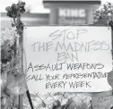  ?? DAVID ZALUBOWSKI/AP ?? A sign hangs April 23 amid tributes at the King Soopers grocery store where 10 people died in a mass shooting in late March in Boulder, Colorado.