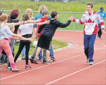  ?? THE NEWS FILE PHOTO ?? Pictou County’s Daniel Martin, who won a gold medal and a silver at the 2017 Special Olympics winter games in Austria, greets fans during the 2017 Michelin Torch Run.
