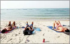  ?? (AFP) ?? Sunbathers lie on the beach in Salmiya district, some 20 kms (12 miles) east of the capital Kuwait City on July 7. Temperatur­es regularly soar in Kuwait in the
summer to over 50 degrees Celsius.