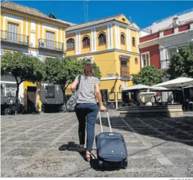  ?? JUAN CARLOS MUÑOZ ?? Una mujer cruza con una maleta de ruedas la Plaza de la Alianza, en el turístico barrio de Santa Cruz.