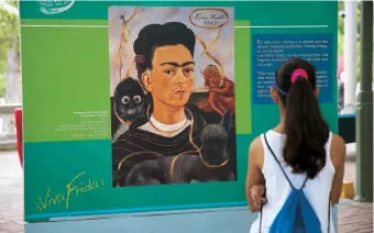  ??  ?? Una niña observa un autoretrat­o de la pintora mexicana Frida Khalo.