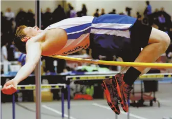  ?? HERALD PHOTOS BY MARK LORENZ ?? UP AND OVER: Dover-Sherborn’s Danny Bennett competes in the high jump during the Division 5 Coaches Relays yesterday at the Reggie Lewis Center. Below, Lauren Sablone, left, reacts after anchoring Austin Prep to a 4x400 sprint medley win.