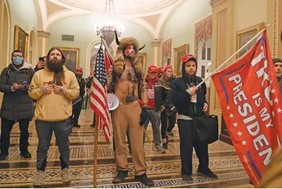  ?? Picture: AFP ?? 'DIGITAL SOLDIER'. Supporters of US President Donald Trump, including member of the QAnon conspiracy group Jake Angeli, centre, enter the US Capitol on Wednesday in Washington, DC.