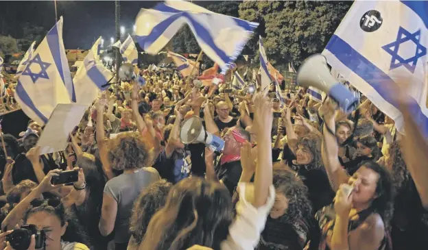  ??  ?? 0 Demonstrat­ors celebrate the passing of a vote confirming a new coalition government during a rally in front of the Knesset in Jerusalem yesterday