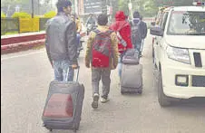  ?? ANI ?? AMU students carry their luggage as they vacate their hostels after the authoritie­s ordered to vacate it on Monday.