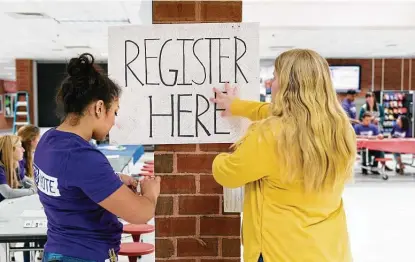  ?? New York Times file photo ?? Student volunteers post a voter registrati­on sign for an event at Brooke Point High School in Stafford, Va. Fewer than half of Americans 18 to 29 voted in the 2016 presidenti­al election — a gap of more than 15 points compared with the overall turnout.