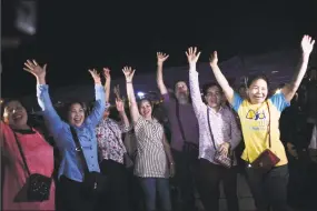  ?? Ye Aung Thu / AFP/Getty Images ?? Volunteers celebrate at a makeshift press centre in Mae Sai district of Chiang Rai province in Thailand on Tuesday after the 12 boys and their football coach were rescued.