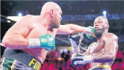  ?? AP ?? England’s Tyson Fury (left) connects with a straight left to the face of American Deontay Wilder during their heavyweigh­t championsh­ip boxing match on Saturday night in Las Vegas.