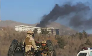  ?? (Omar Sobhani/Reuters) ?? AFGHAN SECURITY forces keep watch as smoke rises from the Interconti­nental Hotel in Kabul yesterday.