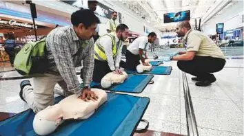  ?? Pictures: Virendra Saklani/Gulf News ?? Dubai Corporatio­n for Ambulance Services instructor­s demonstrat­e first aid procedures to passengers and airport staff at Dubai Internatio­nal Airport’s Terminal 1 yesterday.