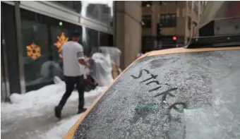  ?? NANCY LANE / BOSTON HERALD ?? MESSAGE RECEIVED: The word ‘strike’ is written in fake snow on the windshield of a car at recent filming of the movie ‘Spirited’ downtown. Below, a sign directs film crew parking in Brockton for the Netflix movie ‘Don’t Look Up.’ The film industry has grown rapidly across the Bay State.