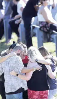  ?? AP ?? People gather waiting for word from students at Coral Springs Drive and the Sawgrass Expressway just south of the campus following a deadly shooting at Marjory Stoneman Douglas High School in Parkland, Florida, on February 14.