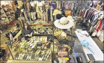  ?? HYOSUB SHIN / HSHIN@AJC.COM ?? Christy Ogletree Ahlers, owner of Peachtree Battle Estate Sales and Liquidatio­ns, prepares for the estate sale of Diane McIver’s wardrobe. More than 2,000 of her articles of clothing, jewelry, hats and shoes are on display in a warehouse showroom.