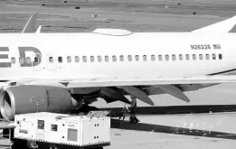  ?? AP ?? A Medford Jet Center worker walks under a United Boeing 737-824 that landed at Rogue Valley Internatio­nal-Medford Airport from San Francisco with a missing panel in Medford, Oregon.