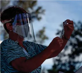  ?? ERIC HASERT/TCPALM ?? Lynnette Essig, a licensed practical nurse with the Visiting Nurse Associatio­n, prepares a dose of influenza vaccine Oct. 7, 2020, in Vero Beach.