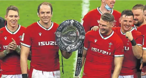  ??  ?? Wales skipper Alun Wyn Jones, second left, lifts the Triple Crown after his side’s historic win over England in Cardiff.