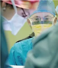  ?? WARD PERRIN/Postmedia News file photo ?? Medical student James Reid watches Dr. Tracy Scott operate to remove a tumour from a patient. Unemployme­nt among
doctors is the focus of a national summit this week.