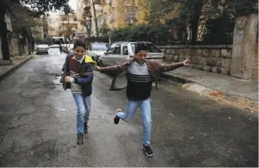  ?? Hassan Ammar / Associated Press ?? Adeeb Ayoub, 13, (right) who left with an uncle in 2015, returned to Aleppo last year from Germany.