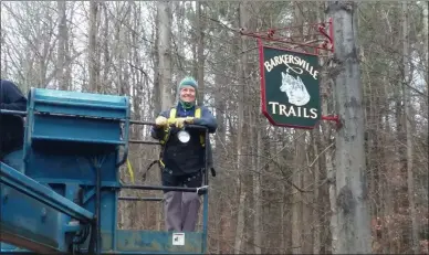  ?? PHOTO PROVIDED ?? Signmaker Kendra Schieber installs a sign for the newBarkers­ville Trails.