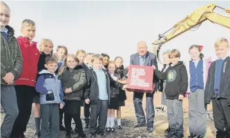  ??  ?? Sir Bob Murray buries a time capsule underneath the Beacon of Light alongside pupils from Southwick Community Primary School.