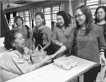  ??  ?? Caroline (front, second right) and the MPWK Mas Gading delegates share a light moment with one of the patients at Bau Hospital.