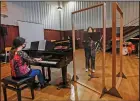  ??  ?? Ylenia Labanca (left) plays piano with a singer Yidan Fu behind a transparen­t panel during a lesson at the Giuseppe Verdi Music Conservato­ry.