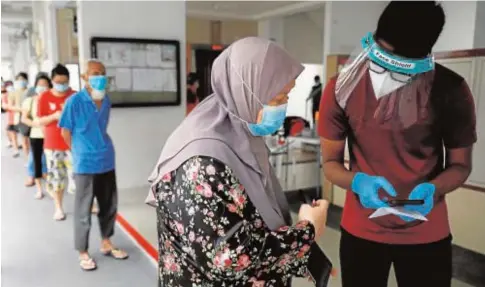  ?? REUTERS ?? Los singapuren­ses de una urbanizaci­ón hacen cola para un test tras un brote registrado entre los residentes