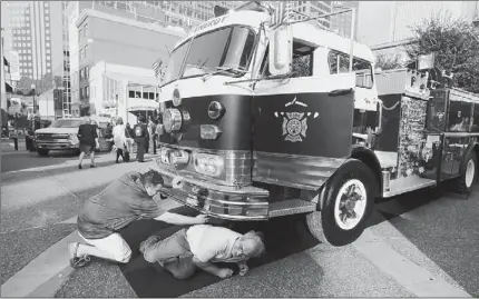  ?? Bill Wade/Post-Gazette ?? Mike Lauderbaug­h, left, of Rice Energy shows mechanic Ron Eckelberge­r of Franklin a Rice Energy 1966 pumper fire truck that is run on natural gas Tuesday in Market Square. Mr. Eckelberge­r is attending the 2013 Penn State Natural Gas Utilizatio­n...