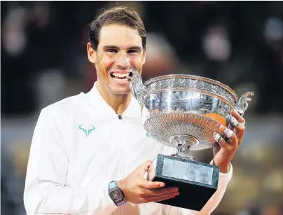  ?? PHOTO: GETTY IMAGES ?? The taste of success . . . Spaniard Rafael Nadal bites the winner’s trophy following victory in the French Open men’s singles final against Novak Djokovic, of Serbia, at Roland Garros in Paris yesterday.