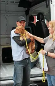  ??  ?? Animal Lifeline volunteer John Busin, left, and Stacy Calvert, West Chester Campus Brandywine Valley SPCA staffer, unload Pickle at the SPCA. Pickle made room for dogs displaced by Harvey and was adopted the next day.